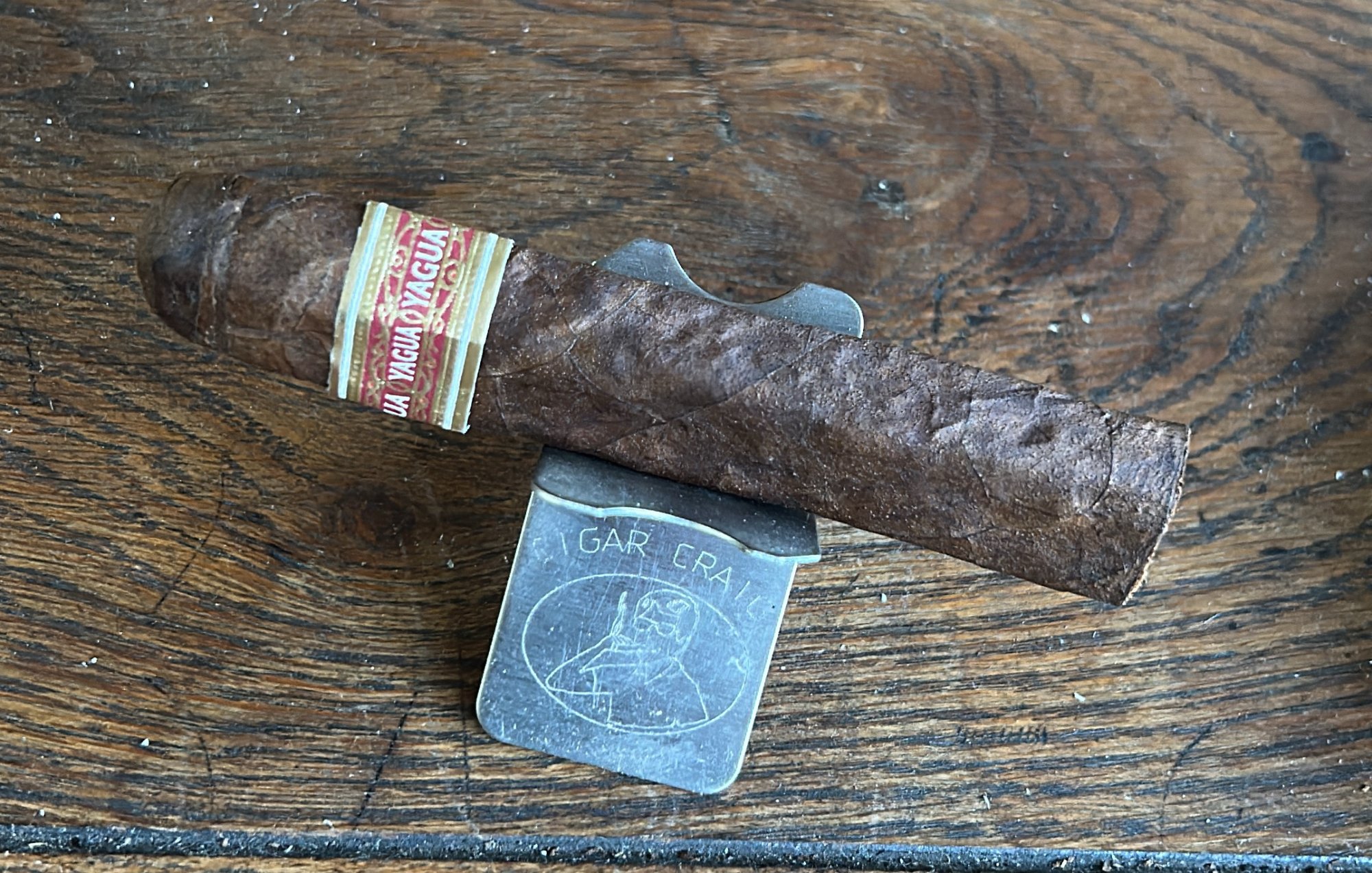 A J.C. Newman Yagua Robusto, lumpy from its palm-leaf wrapping, resting on a CigarCraig cigar rest